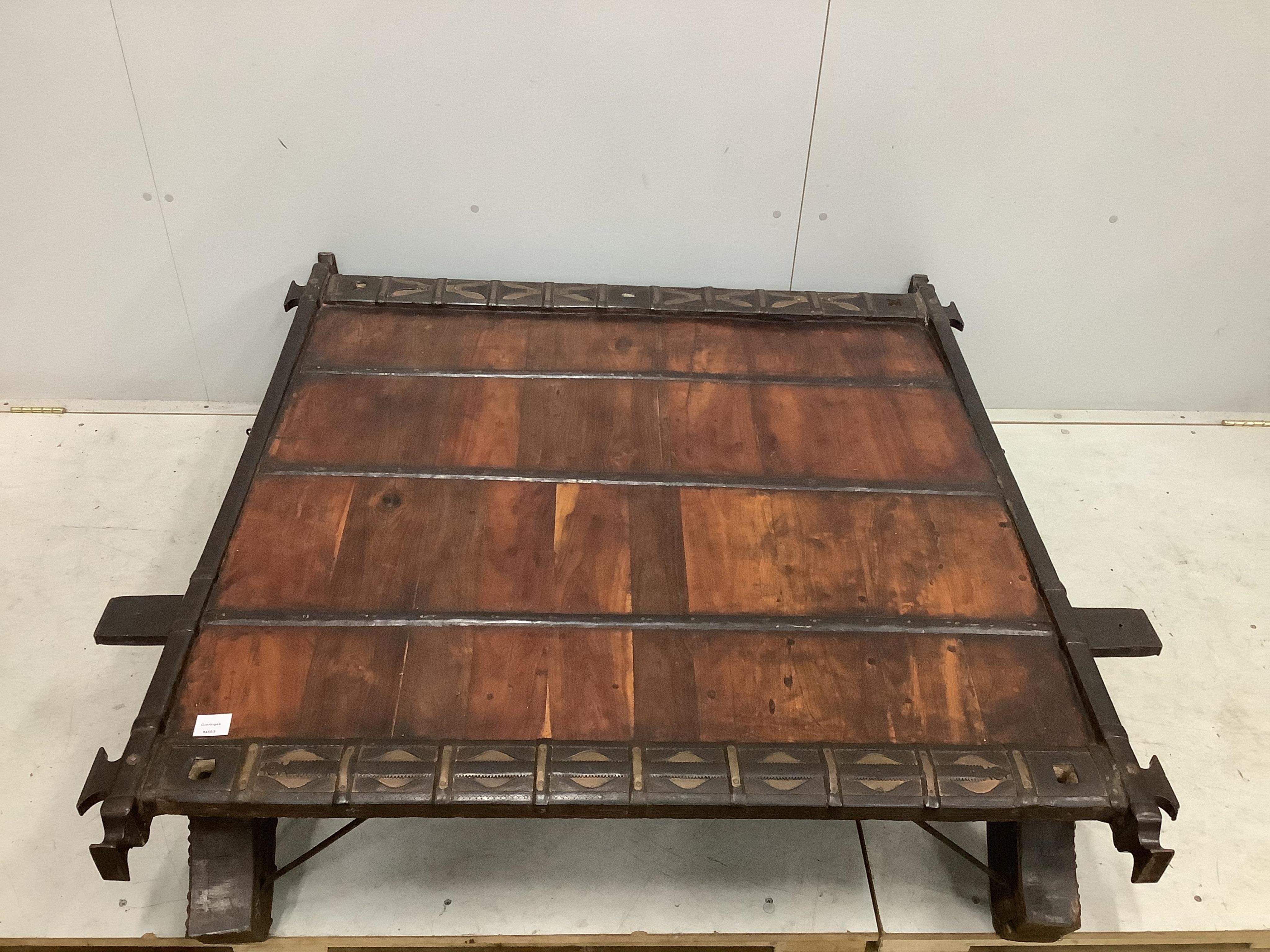 An Indian hardwood and iron mounted low square table, width 138cm, depth 130cm, height 33cm. Condition - fair